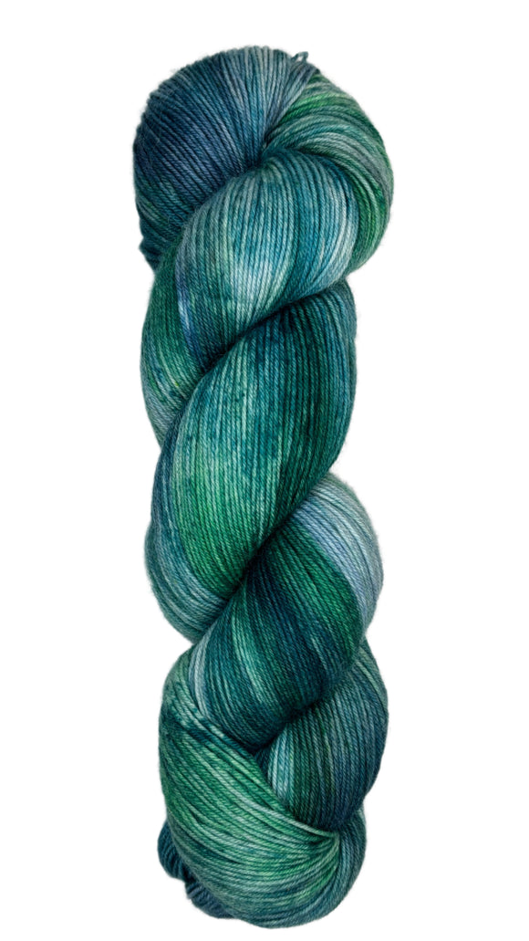 Skein of hand dyed fingering weight yarn in the color blue teal green 