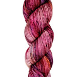 A skein of hand-dyed fingering/sock yarn color red pink blue black speckles