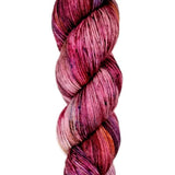 A skein of hand-dyed fingering/sock yarn color red pink blue black speckles