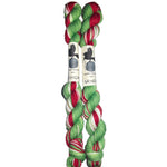 Two skeins of red, green, and white yarn on a white background