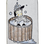 Small rectangular tin with a cartoon design of a sheep in a wooden bathtub on a white background