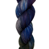 A skein of hand-dyed fingering/sock yarn color grey navy brown purple 