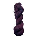 Purple and navy skein of yarn on a white background