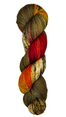 Skein of hand dyed fingering weight yarn in the color brown offwhite red orange black speckles