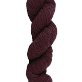 Wine colored skein of mountain meadow wool yarn on a white background