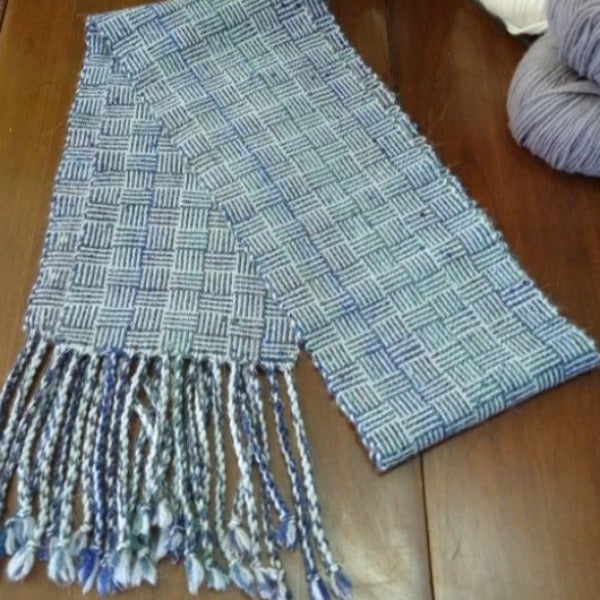 A folded, woven scarf on a table