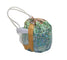 A small drawstring pouch with a holographic mosaic pattern in shades of green, blue, and silver, featuring a tan strap and white drawstring cords, set against a plain white background.