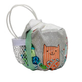 A small fabric pouch with a white handle, featuring a gray polka-dot body, and a colorful print of an orange cat and other cartoon characters on the front.