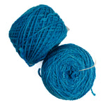 Two balls of teal blue yarn on a plain white background.