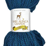 Teal skein of yarn with a label on a white background