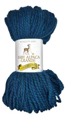 Teal skein of yarn with a label on a white background