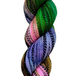Multi colored green, brown, pink, and purple yarn on a zebra (black and white striped) base