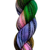 Multi colored green, brown, pink, and purple yarn on a zebra (black and white striped) base