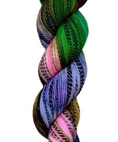 Multi colored green, brown, pink, and purple yarn on a zebra (black and white striped) base