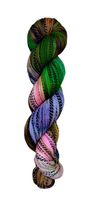 Multi colored green, brown, pink, and purple yarn on a zebra (black and white striped) base