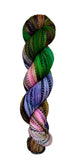 Multi colored green, brown, pink, and purple yarn on a zebra (black and white striped) base