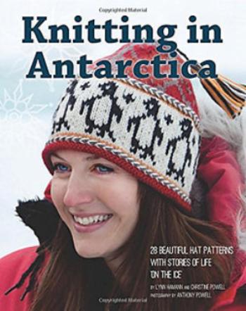 Knitting in Antarctica. Woman with red coat; red, white and black penguin hat