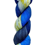 A skein of hand-dyed fingering/sock yarn color grey white blue navy black speckles