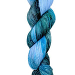 A skein of hand-dyed fingering/sock yarn color blue green black speckles