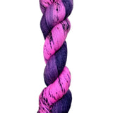 A skein of hand-dyed fingering/sock yarn color pink purple dark navy black speckles