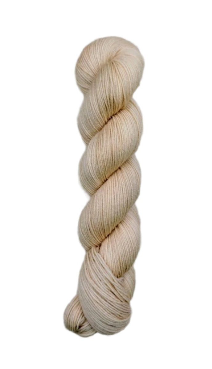 A skein of hand-dyed fingering/sock yarn color off white pink tan