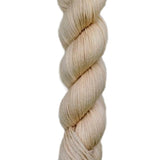 A skein of hand-dyed fingering/sock yarn color off white pink tan
