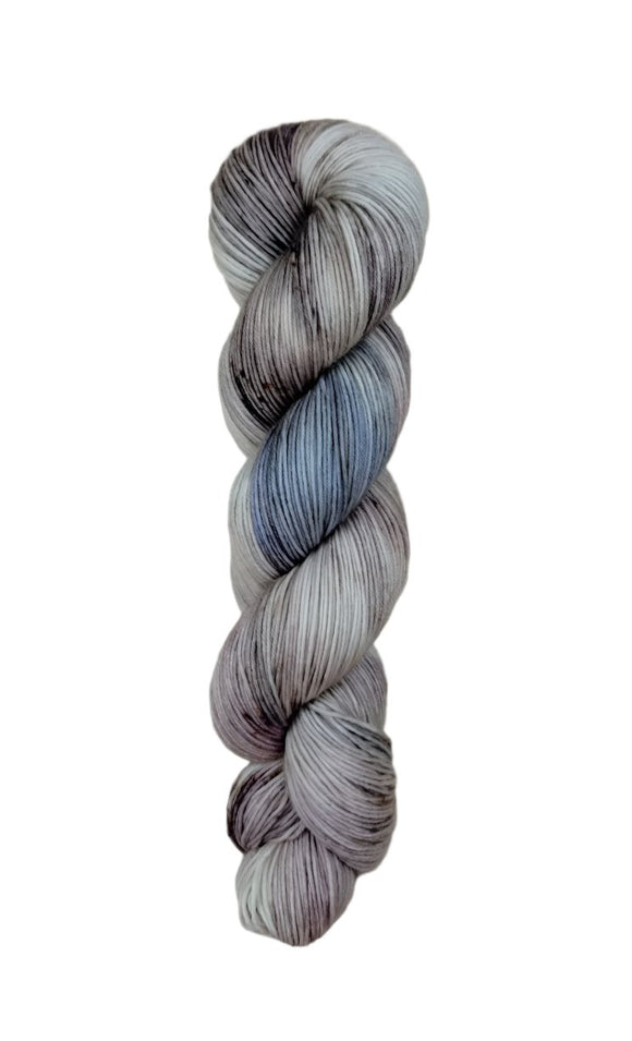 A skein of hand-dyed fingering/sock yarn color grey blue black speckles