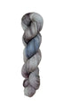 A skein of hand-dyed fingering/sock yarn color grey blue black speckles
