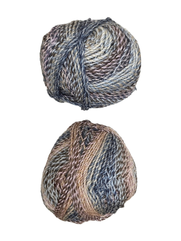 Two skeins of multicolored yarn on a white surface
