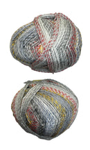A variegated skein of yarn in the colors white grey red orange yellow black