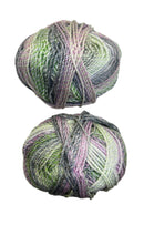 A variegated skein of yarn in the colors green mauve white grey