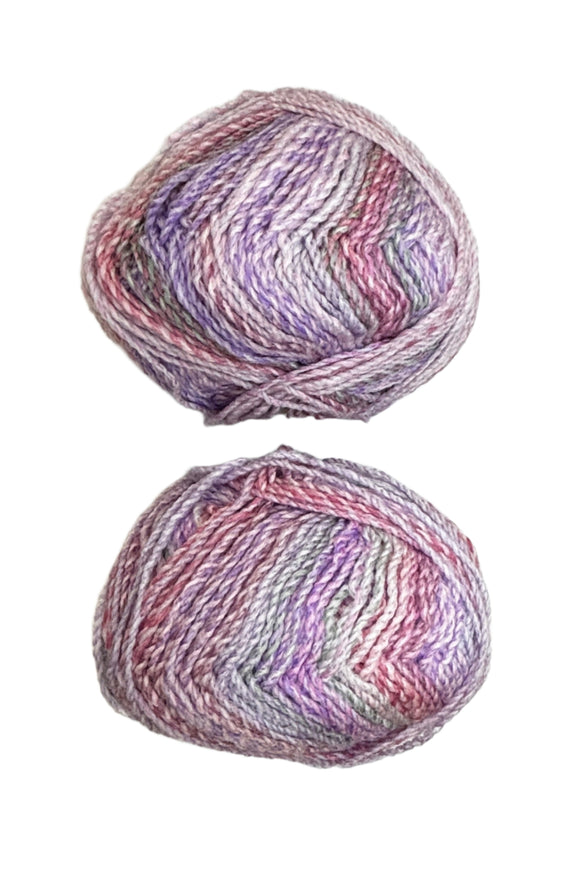 A variegated skein of yarn in the colors pink white grey mauve purple