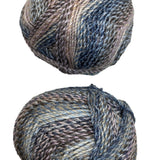 A variegated skein of yarn in the colors mauve white blue black grey navy