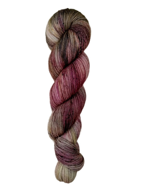 A skein of hand-dyed fingering/sock yarn color brown tan red speckles