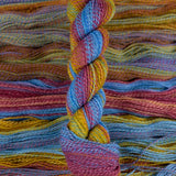 Skein of multicolored handspun looking wool yarn in the colors blue magenta orange yellow purple