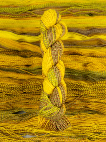 Skein of multicolored handspun looking wool yarn in the colors yellow brown green orange