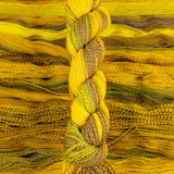 Skein of multicolored handspun looking wool yarn in the colors yellow brown green orange