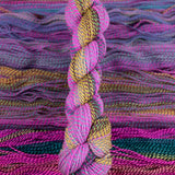 Skein of multicolored handspun looking wool yarn in the colors pink teal yellow burgundy purple 