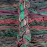 Skein of multicolored handspun looking wool yarn in the colors green pink grey teal brown