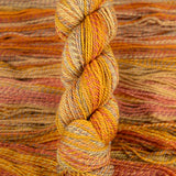 Skein of multicolored handspun looking wool yarn in the colors grey yellow orange off-white red brown