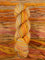 Skein of multicolored handspun looking wool yarn in the colors grey yellow orange off-white red brown