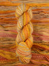 Skein of multicolored handspun looking wool yarn in the colors grey yellow orange off-white red brown
