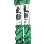 Two mini skeins of wool yarn hand dyed in Wyoming in the color green and black streaks