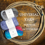 Multicolored Balls of Universal Yarn Maman Acrylic Yarn on a wooden surface