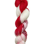 A skein of hand-dyed fingering/sock yarn color white red speckles