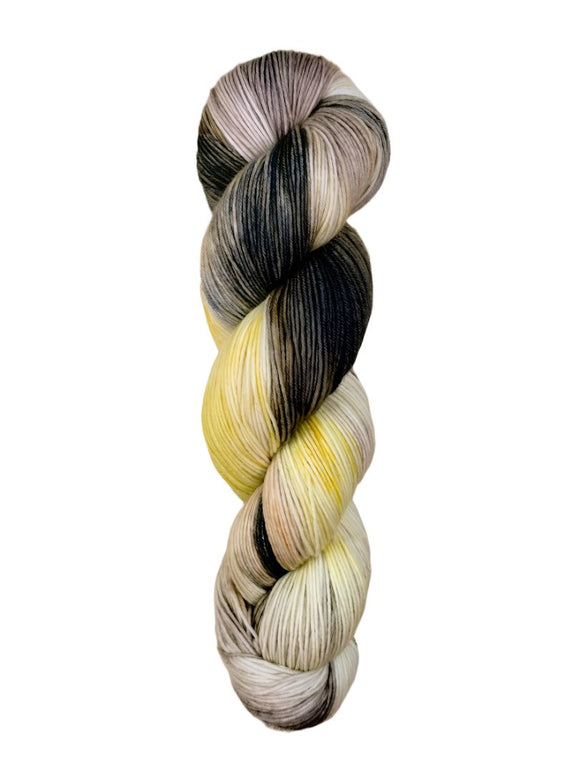 A skein of hand-dyed fingering/sock yarn color grey yellow peach mauve black