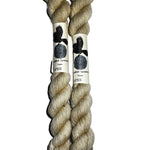 Two mini skeins of  off white yarn on a white background 