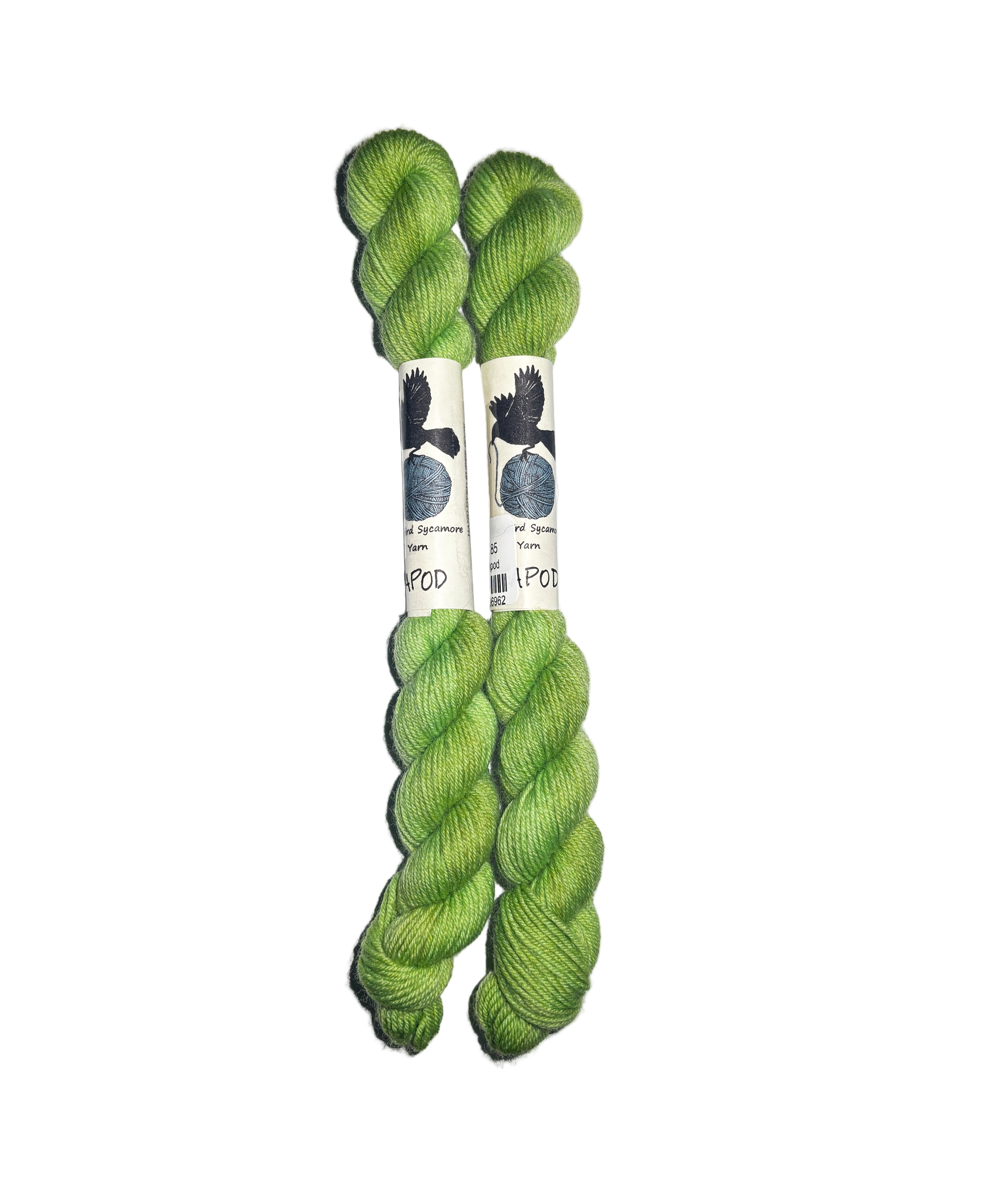 Two mini skeins of green yarn in the color green on a white background