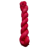 Braided pink yarn on a white background