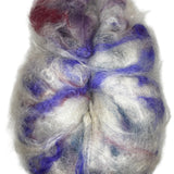A rolag of wool fiber ready to spin in the colors natural white purple red blue 